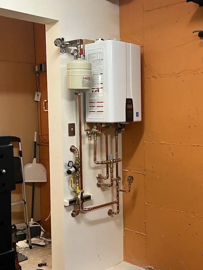 Plumbing technician inspecting water heater connections in Brady